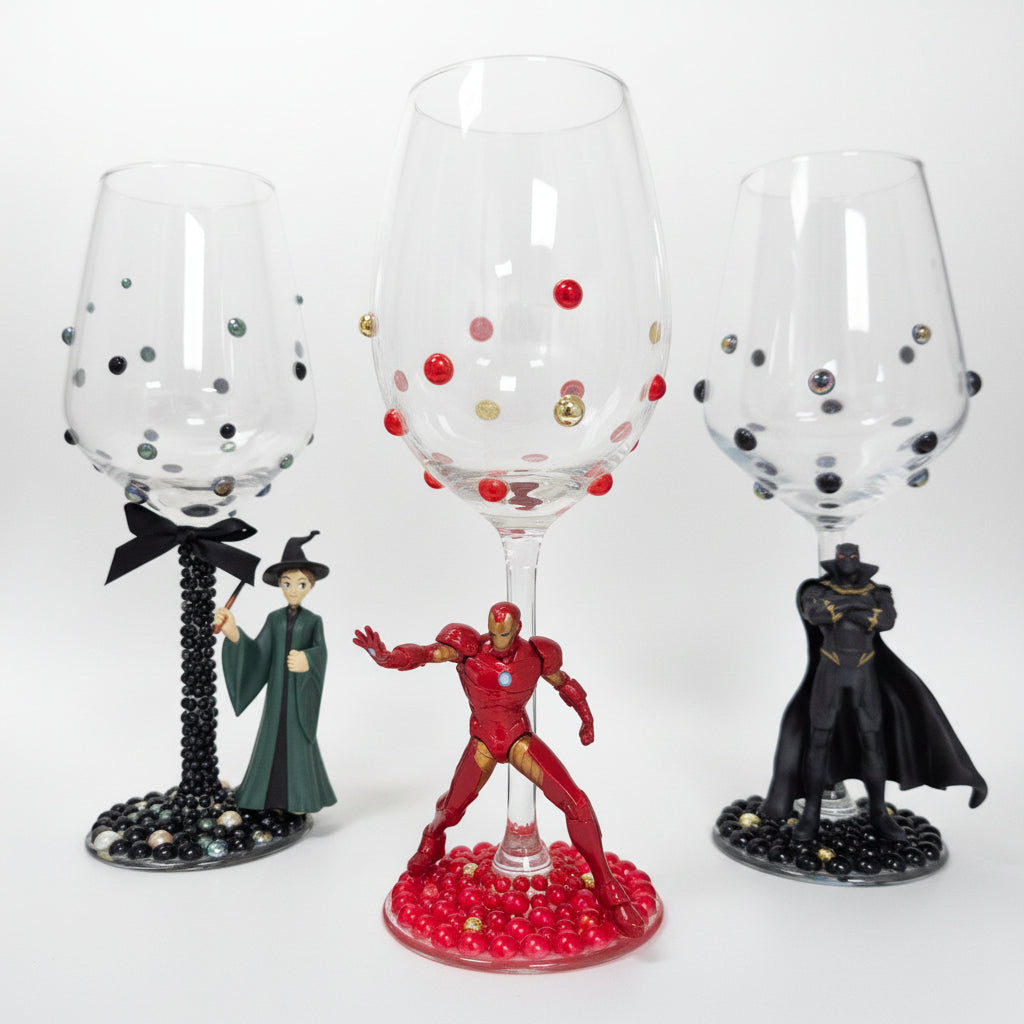 Decorative wine glasses with figurines on a white surface
