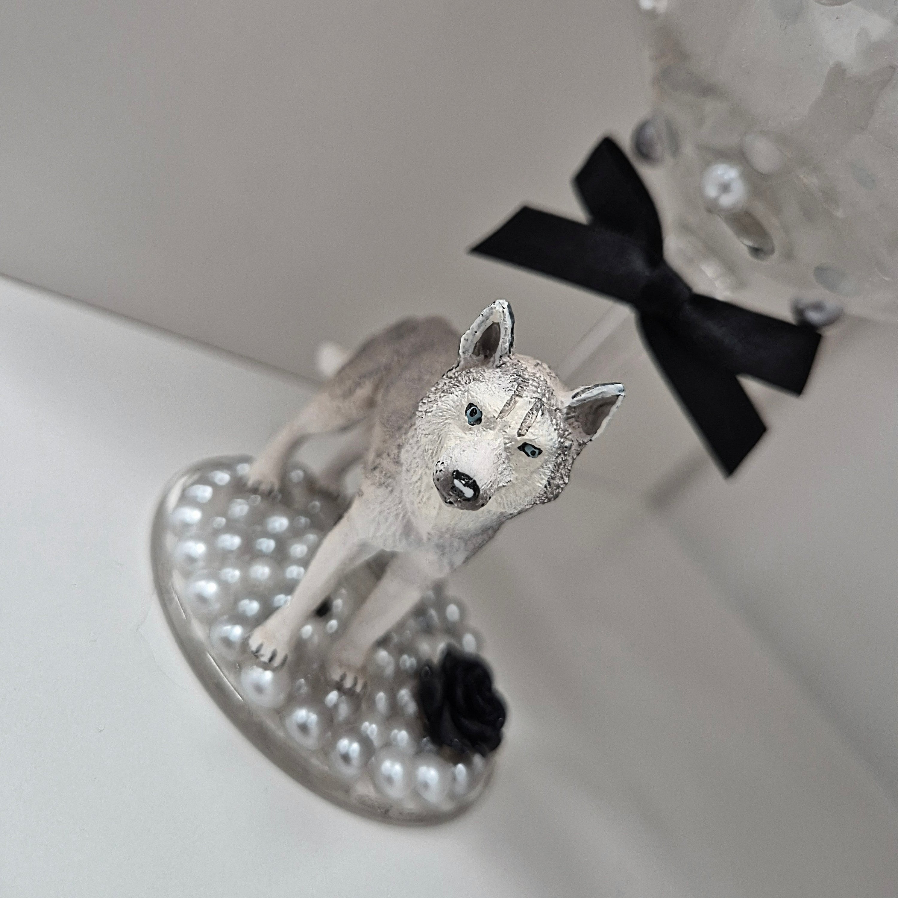 Dog figurine on a large stemmed glass with a black bow