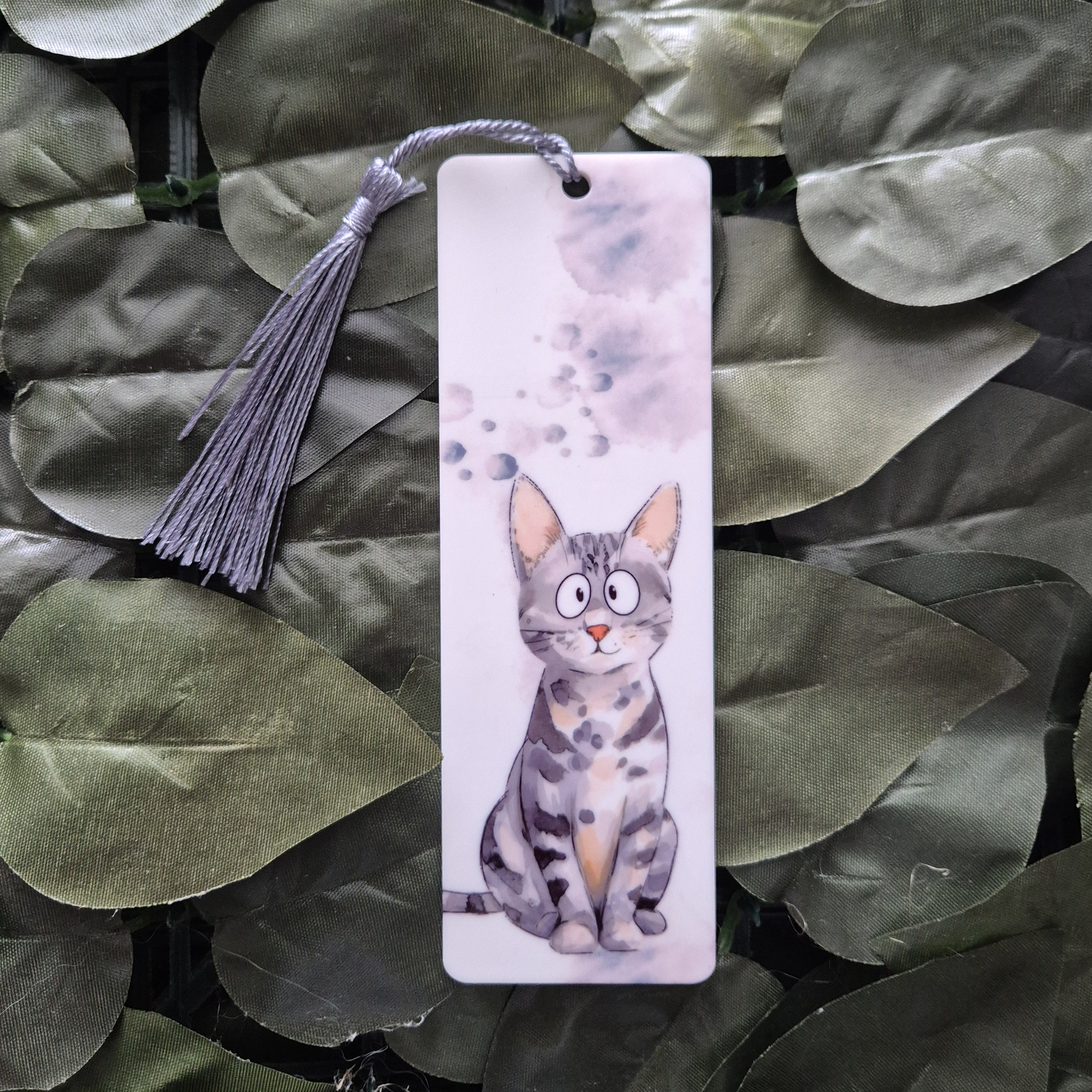 Bookmark with a cat illustration on a leafy background
