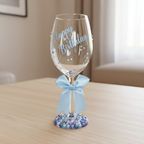 Wine glass with 'Happy Birthday' text, decorative beads, and a blue ribbon.