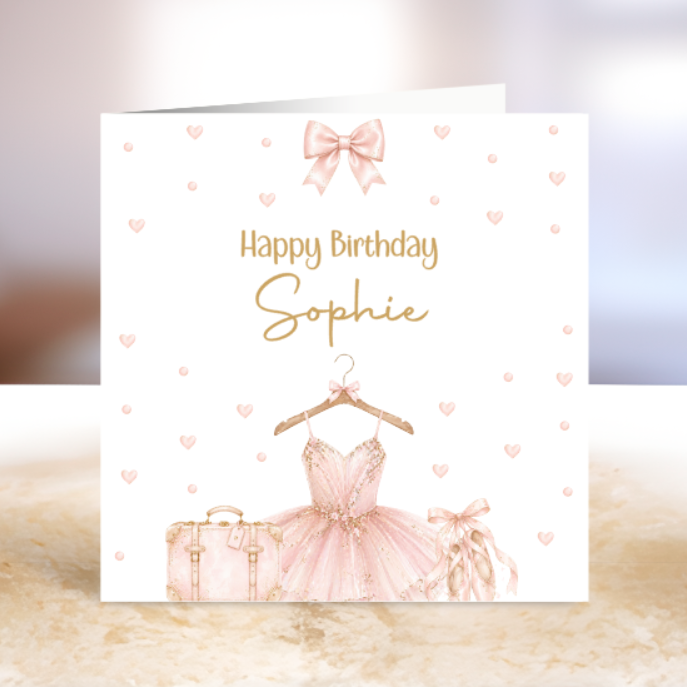 Birthday card with a pink ballerina dress, suitcase, and bow on a white background