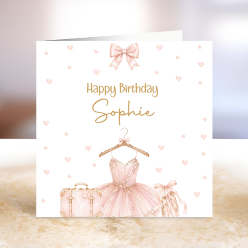Birthday card with a pink ballerina dress, suitcase, and bow on a white background