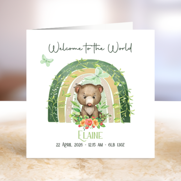 New baby card with a bear illustration and rainbow arch.